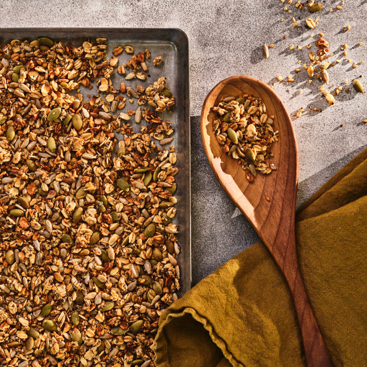 Spices on a baking tray with a wooden spoon and green cloth
