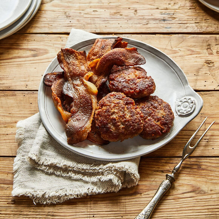 Plated meat dish on a wooden table with a fork